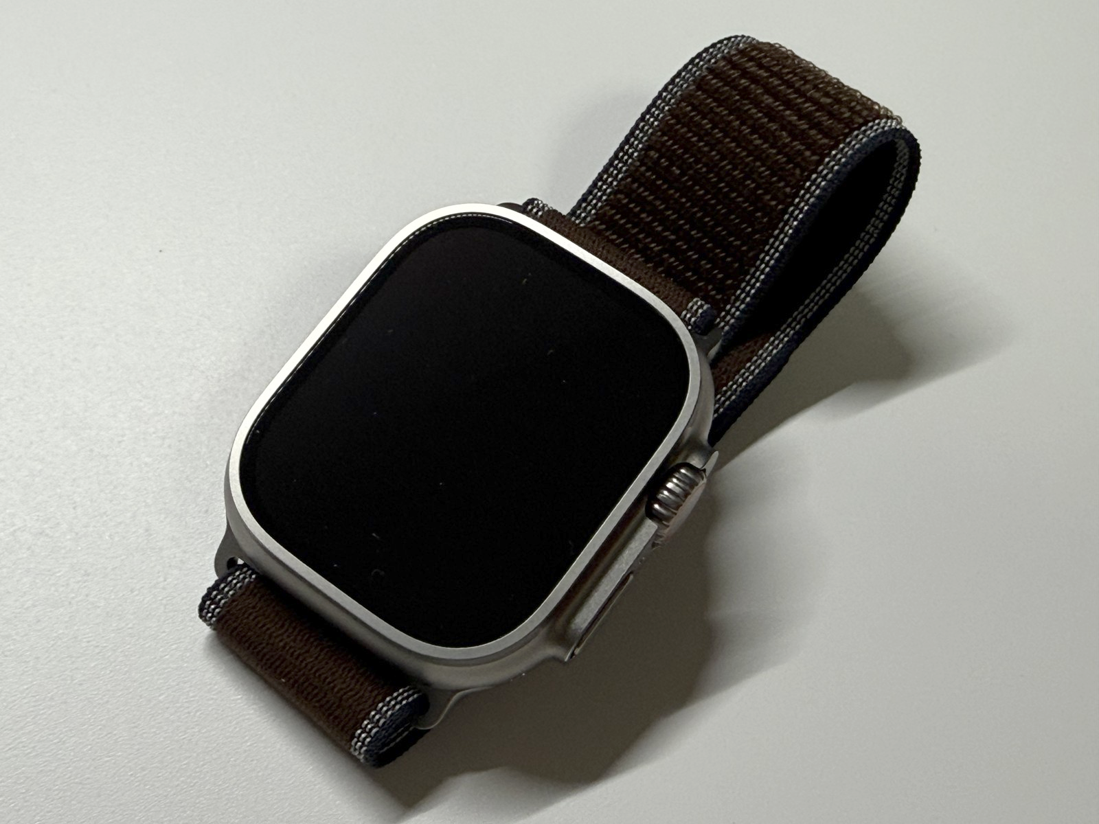 茶系の布製バンドを取り付けたApple Watch Ultra 4を斜めから見た外観