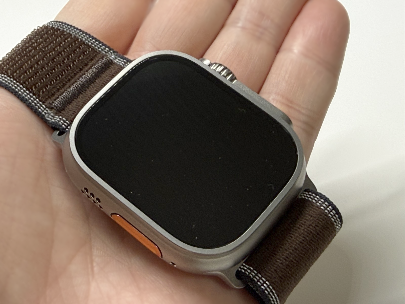 手のひらに載せたApple Watch Ultra 4の前面とオレンジ色のアクションボタン